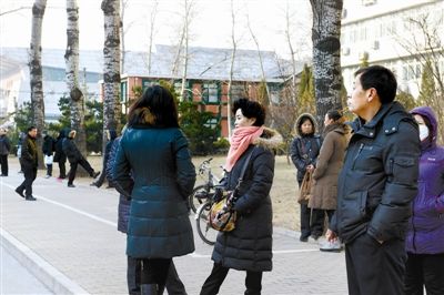 1月6日，2013年全国硕士研究生统一入学考试北京中国人民大学考点，特地从外地赶来陪考的家长在考场外等候考试结束。 　　本报记者 王叔坤 摄