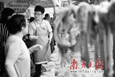  毕业5年后，司汝全(右一)已步入管理层，有时也顺便帮忙卖猪肉 肖雄 摄
